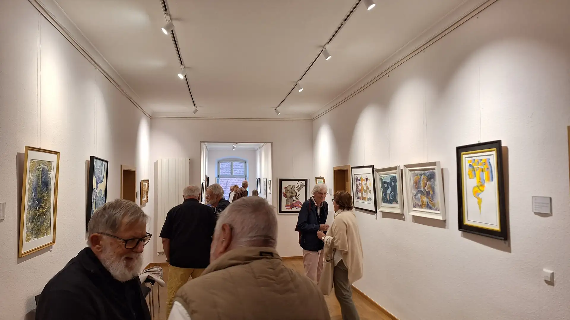 Person bei einer Vernissage im Rathaus, neben einem ausgestellten Kunstwerk