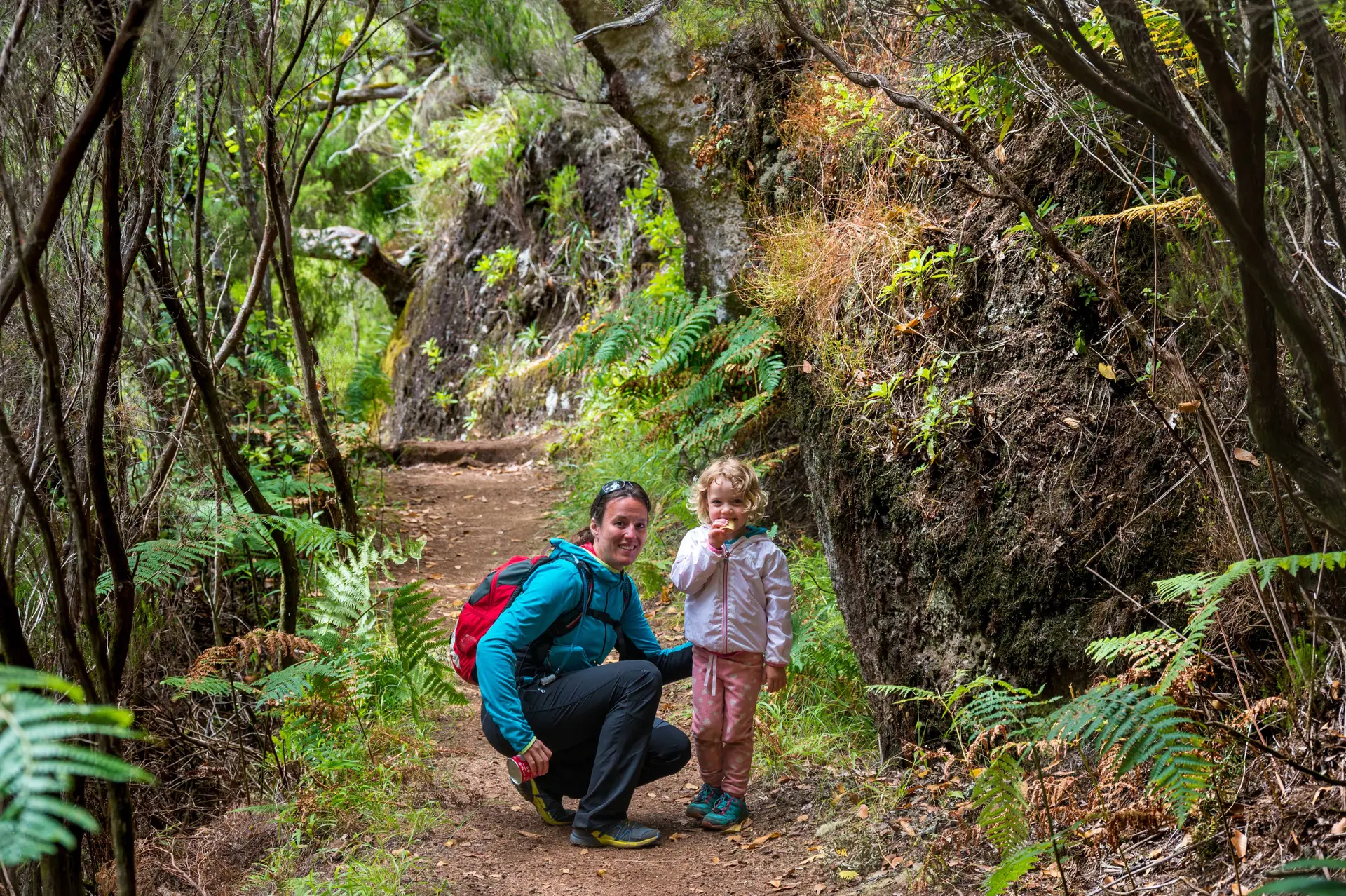 Happy mother and daughter posing on a forest path. Hiking Madeira with family