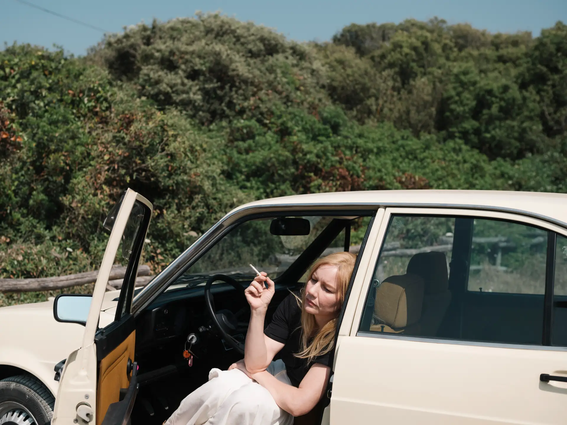 Nachdenklich sitzt Ingeborg Bachmann (Sandra Hüller) in ihrem Auto auf einem Parkplatz am Meer