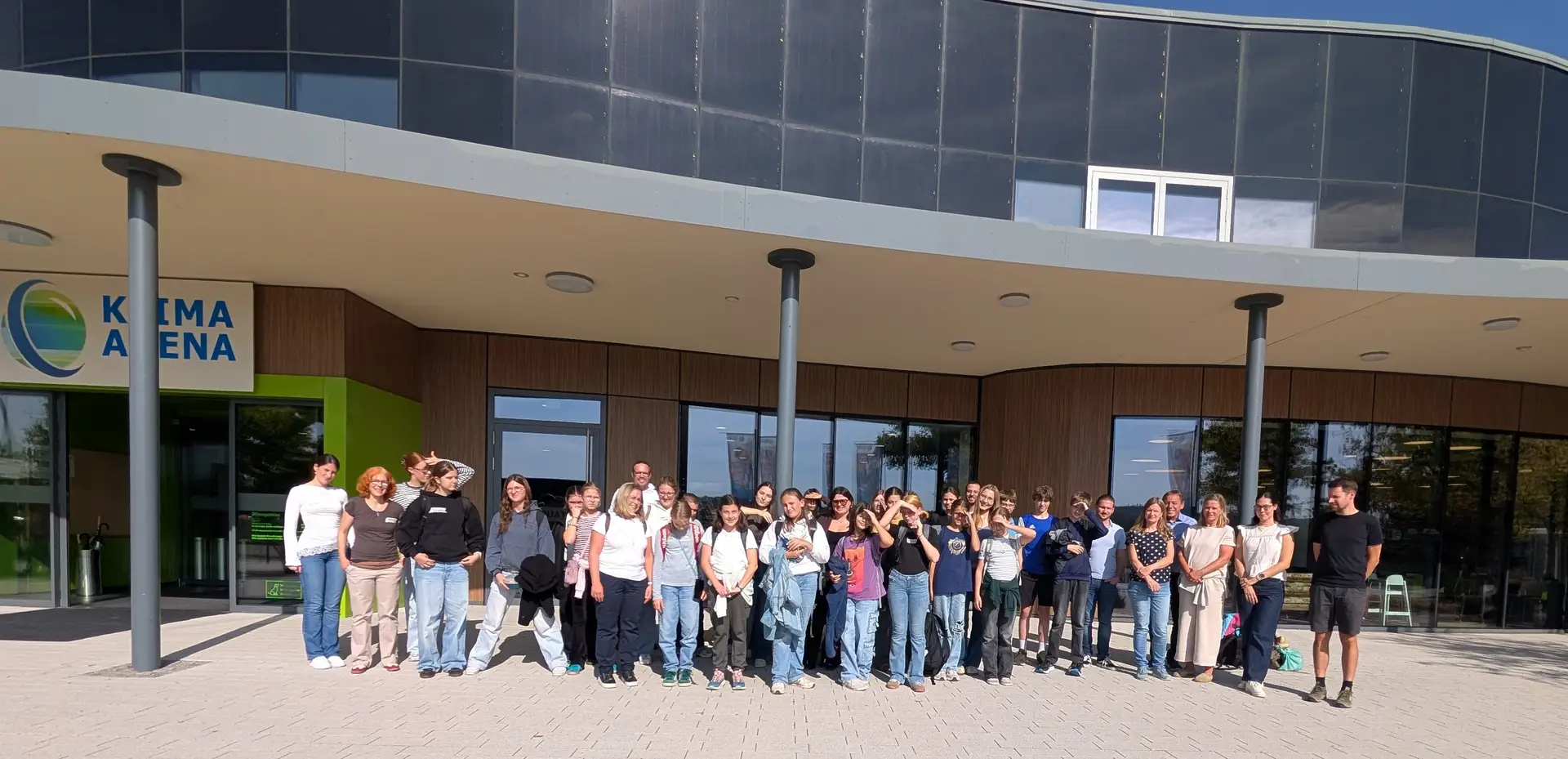 Gruppenfoto von Jugendlichen und Begleitpersonen vor der KLIMA ARENA.