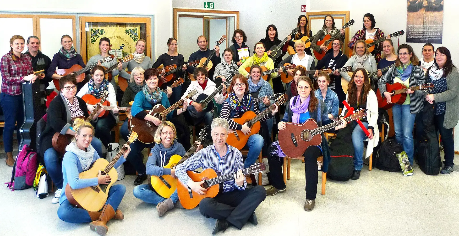 Ein Gitarren- bzw. Ukulelenspieler mit Griffhand an einem Instrument, aufgenommen für eine Presseinformation zum JelGi-Anfänger-Kurs.